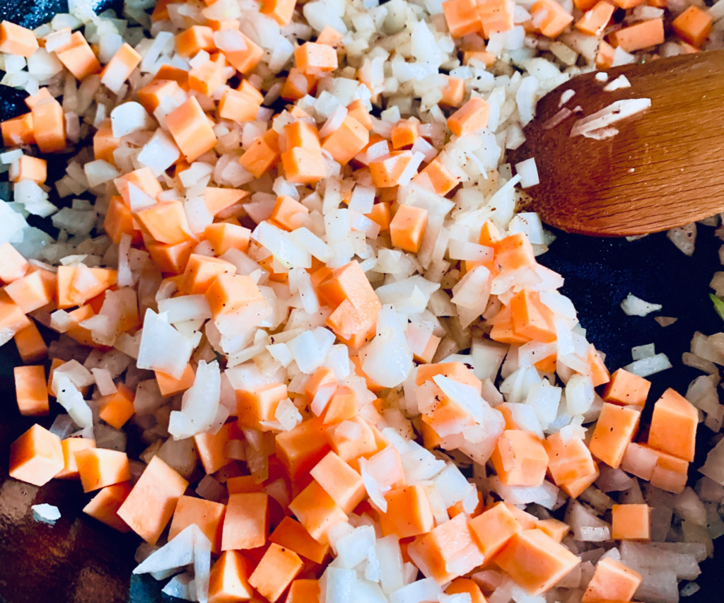 Sweet Potato and onion cooking in a cast iron skillet