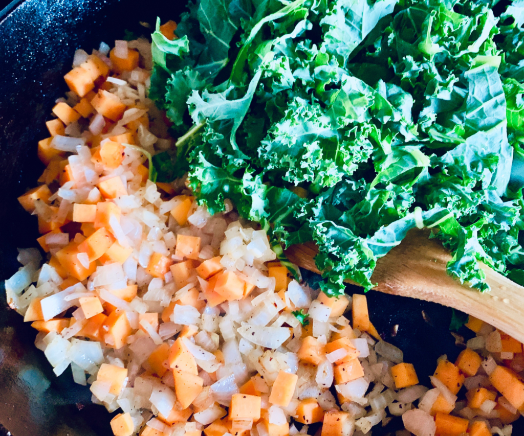 Sweet Potato, onion and Kale in a cast iron skillet